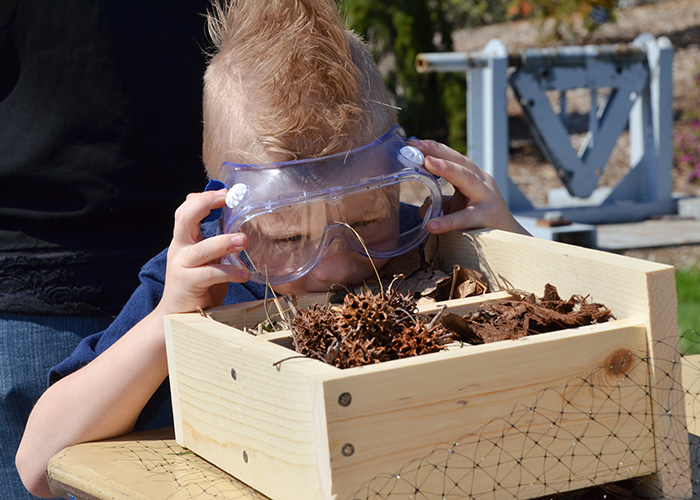 Child constructing an insect hotel